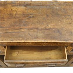 18th century rustic oak dresser base, with fielded panels and iron cup handles with embossed greek key and foliate detail, three short drawers above and open recess flanked by two cupboard doors, raised on stile supports