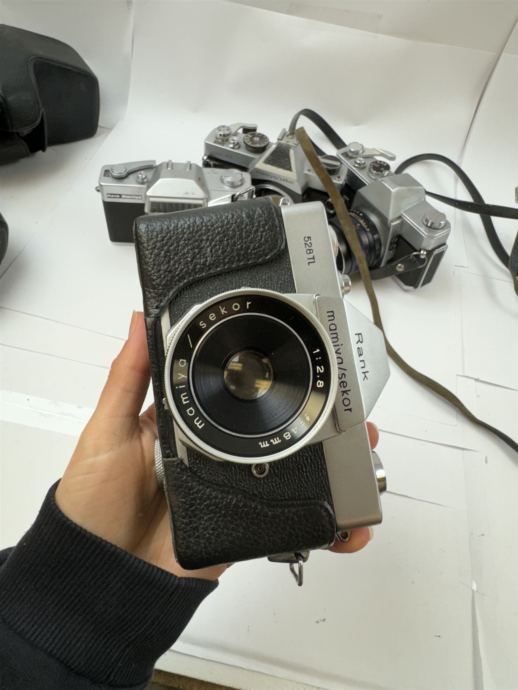 Five Mamiya/Sekor SLR camera bodies, to include autoXTL serial no. PI34456, with a ES 1:18 f=55mm serial no. 28148, Rank 528TL camera body serial no. 18151, with a 1:2.8 f=48mm lens, Rank Mamiya Auto-Lux 35 camera body serial no. 644713, with a 1:2.8 f=48mm lens, 500DTL serial no. 386357, with an Auto 1:2 f=50mm lens serial no. 187863, and one other 