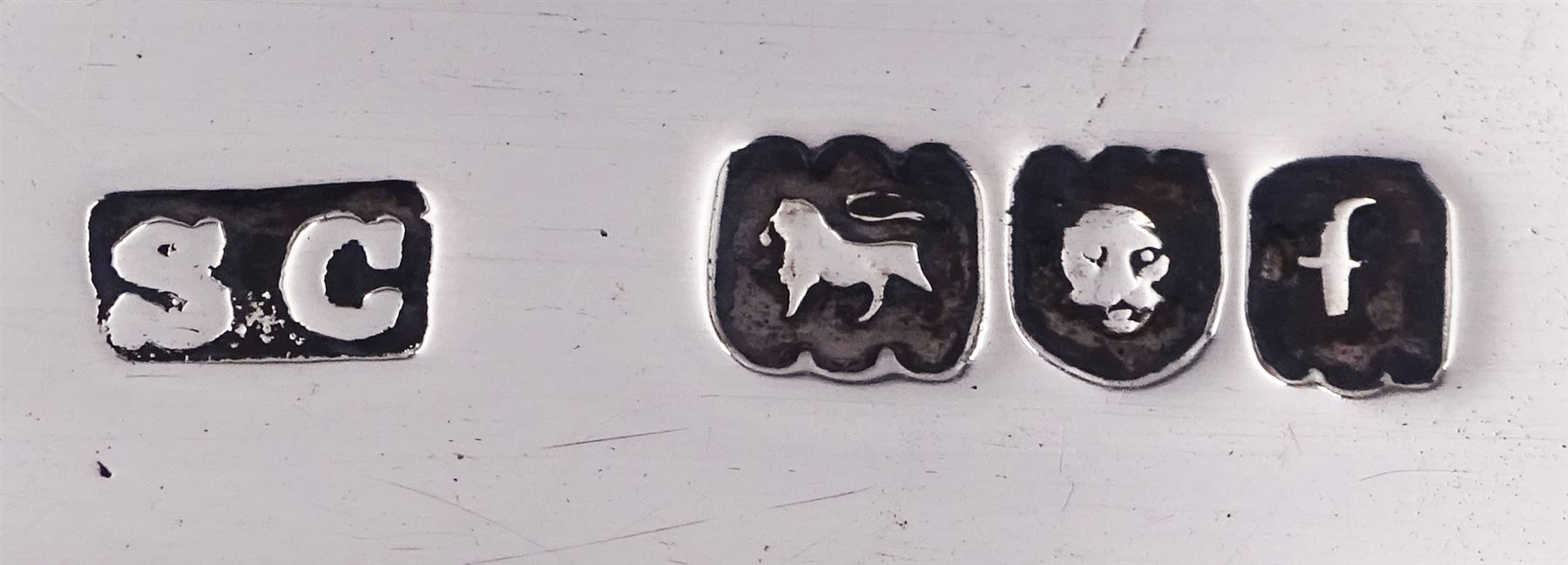 Edwardian silver page marker, with foliate terminal, hallmarked Stuart Clifford, London 1901, L18cm, together with three 20th century century silver napkin rings, to include one example of circular form with reed and ribbon border, hallmarked James Dixon & Sons Ltd, Sheffield 1936, approximate total weight 3.65 ozt (113.4 grams)