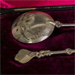 Pair of late Victorian silver serving spoons, each with circular gilt bowls and embossed putti decoration, hallmarked William Hutton & Sons Ltd, London 1895, contained within a tooled leather box with burgundy velvet and silk interior
