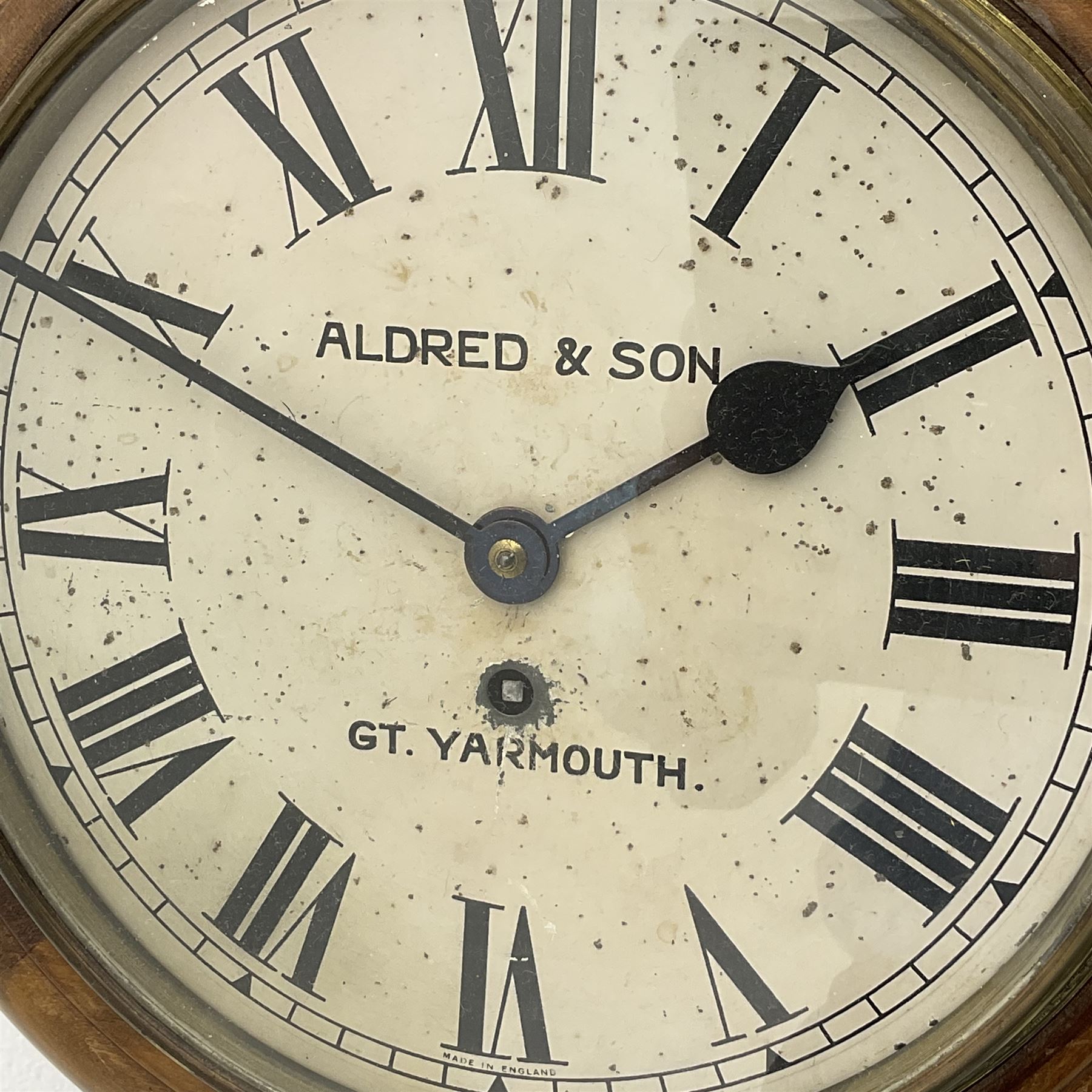 Late 19th century circular wall clock in stained beech case by ‘Aldred & Sons, Gt. Yarmouth’, single train driven movement 