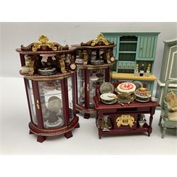 Collection of miniature dolls house furniture, to include display cabinet with pink and white floral dinner service, two serving trolleys with cakes and sweets and two blue painted kitchen dressers, together with miniature dolls house cardboard food packaging and animal figures including dogs and cats, etc