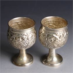 Pair of miniature Indian silver goblets, with embossed floral and foliate decoration, H6.5cm