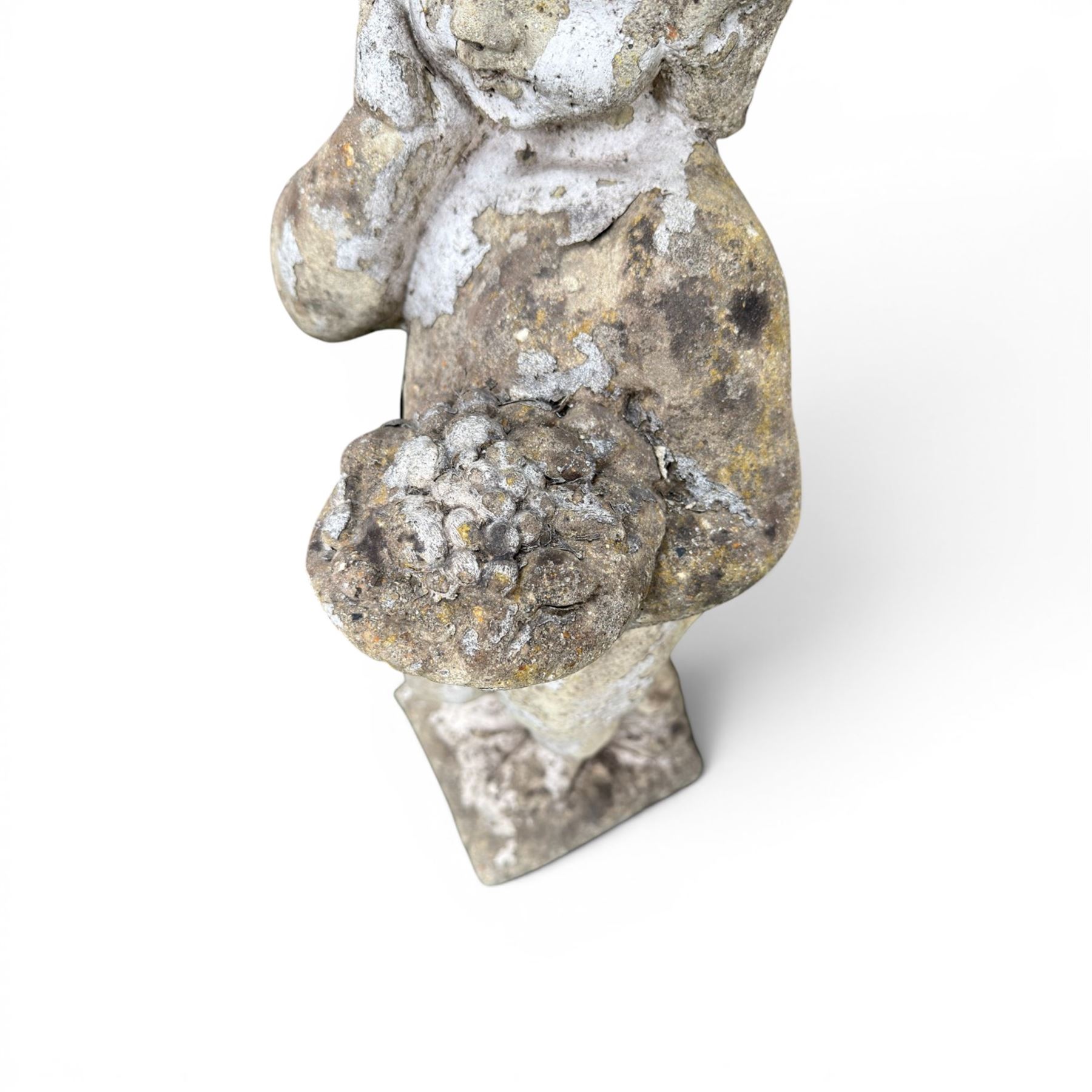 Early composition stone figure of a boy with grape basket, original flakey white paint