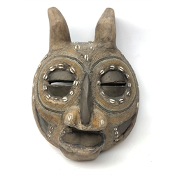  African carved softwood mask with eyes, nose and mouth apertures, inlaid cowrie shells, applied copper panels and beadwork decoration throughout H46cm   