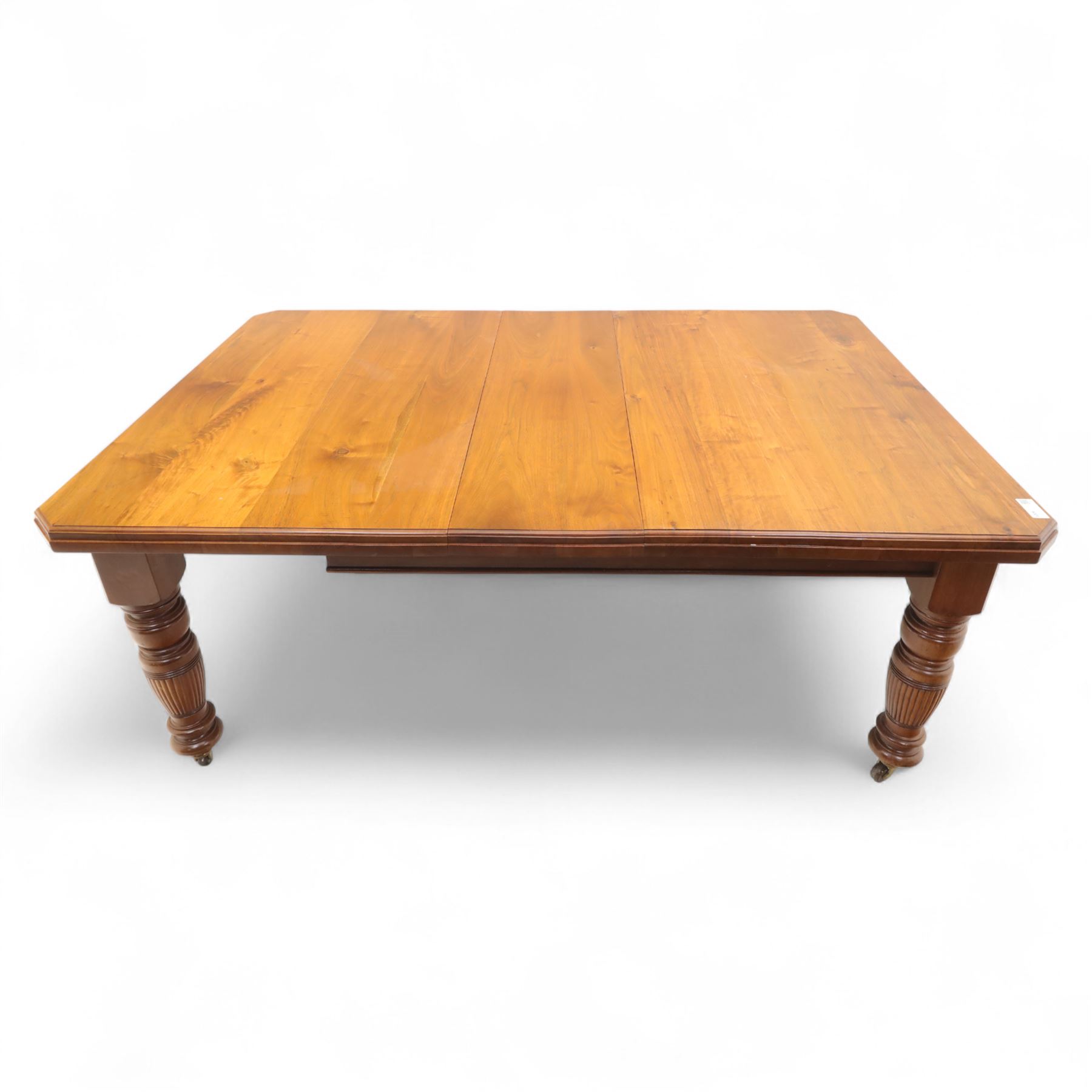 Victorian mahogany extending dining table, rectangular top with chamfered corners above a plain frieze raised on turned reeded legs with castors and two additional leaves, 197cm fully extended, and a set of six early 20th century oak upholstered chairs with drop-in seats, arched panelled back splat and close studded border on turned front legs joined by stretchers, 47x41x109cm 