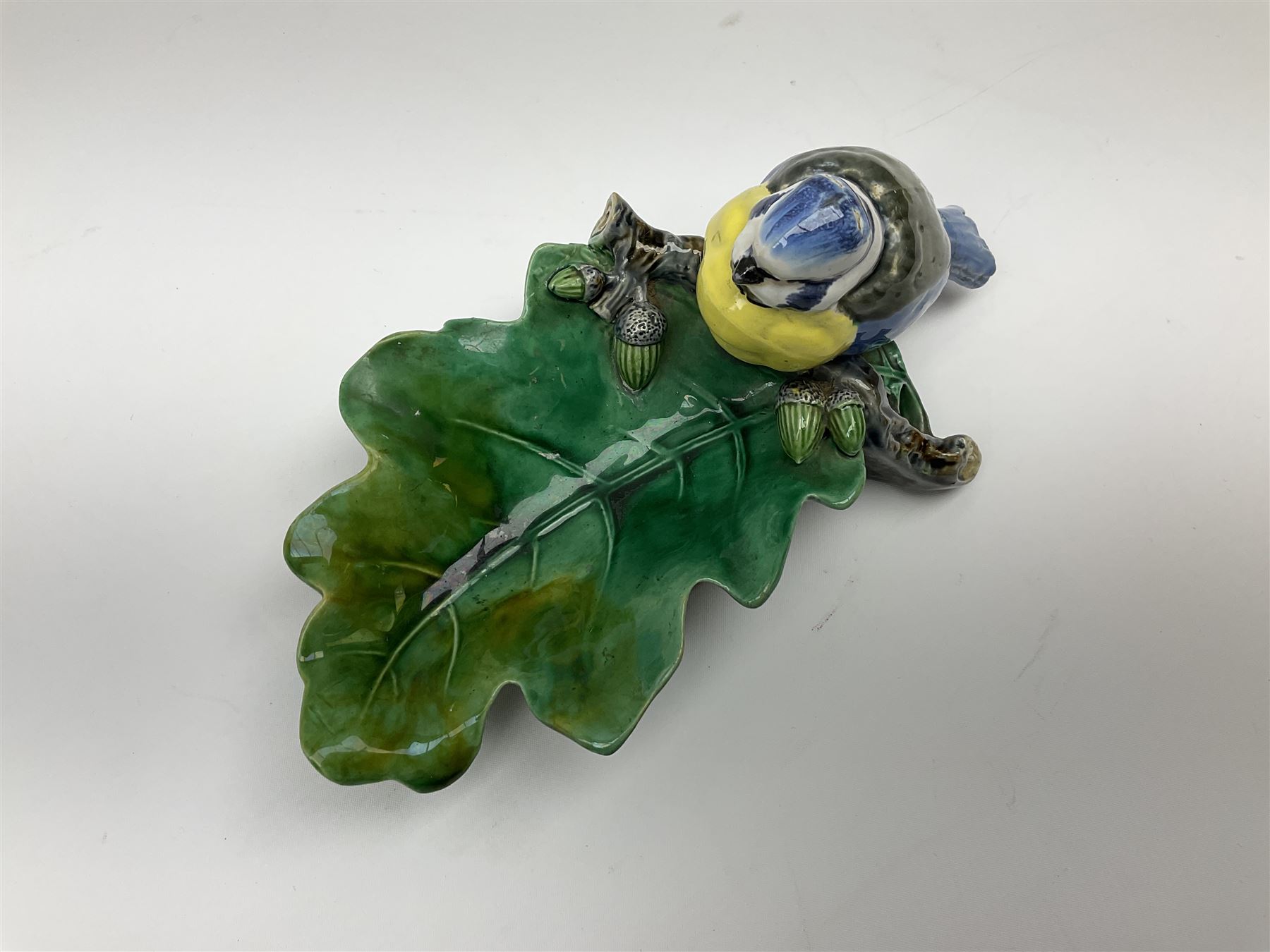 Minton majolica leaf dish, modelled as a Blue Tit perched on a branch with acorns and an oak leaf, date cypher for 1868, impressed marks beneath, L21cm. 