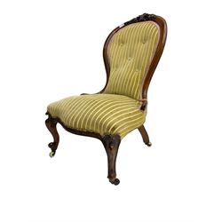 Victorian mahogany framed nursing chair, cresting rail carved with foliate cartouche, upholstered in buttoned striped fabric with sprung seat, raised on cabriole supports terminating in ceramic castors