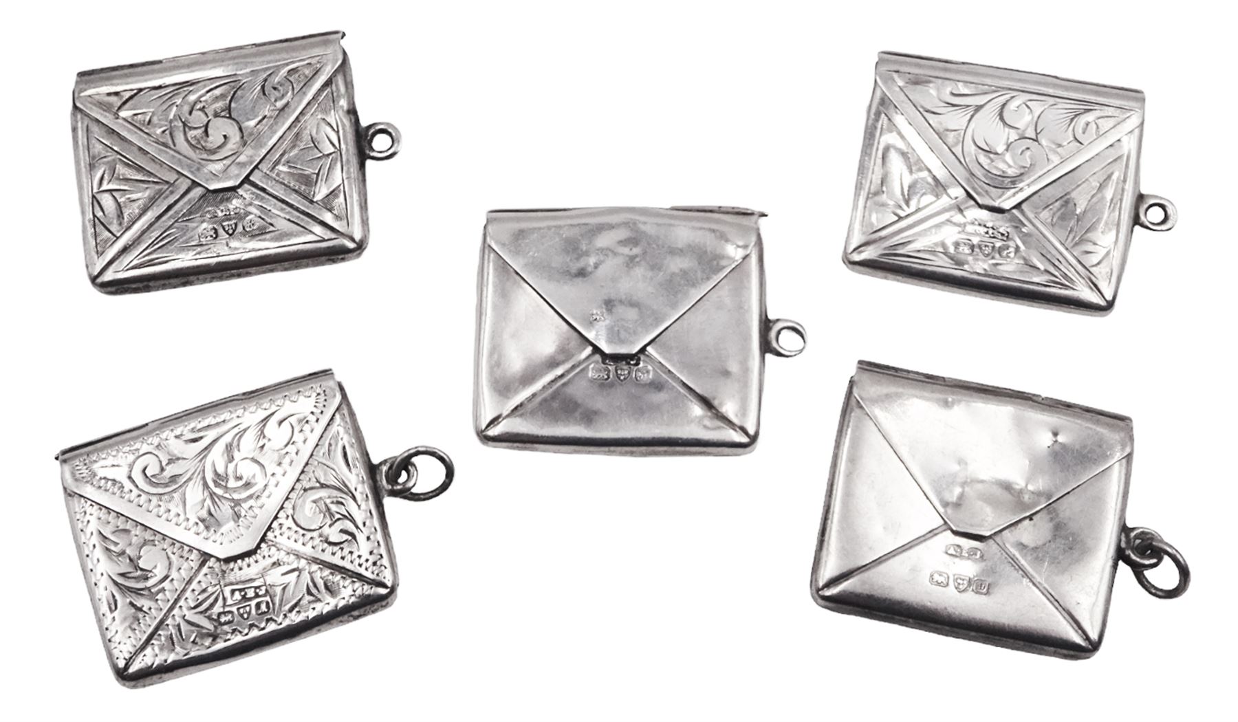 Five early 20th century silver stamp holders modelled in the form of envelopes, comprising three foliate engraved examples, and two plain examples, one with applied detail 'Stamps' verso, hallmarked Albert Ernest Jenkins, (makers mark to one example worn and indistinct),  Chester 1904, 1906, 1908 and 1912, approximate total weight 0.60 ozt (18.6 grams)