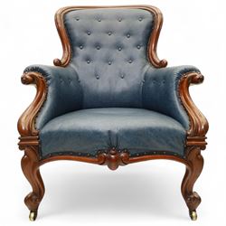 Fine pair of mid-19th-century mahogany library armchairs, carved frame with balloon-shaped back with scrolled ends, rolled wide arms, ending in a scrolled volute above a serpentine seat rail, upholstered in mottled turquoise faux leather, button upholstered back, arms, and cushion seat, studded sides and apron, raised on scroll carved front feet and splayed rear legs on castors 