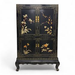 Late 20th century Chinoiserie black lacquer cabinet, the rectangular body decorated with hand-painted floral and foliate motifs in polychrome and gilt, fitted with four panel doors enclosing shelved interior, on shaped apron and stylised cabriole supports with gilt scrollwork