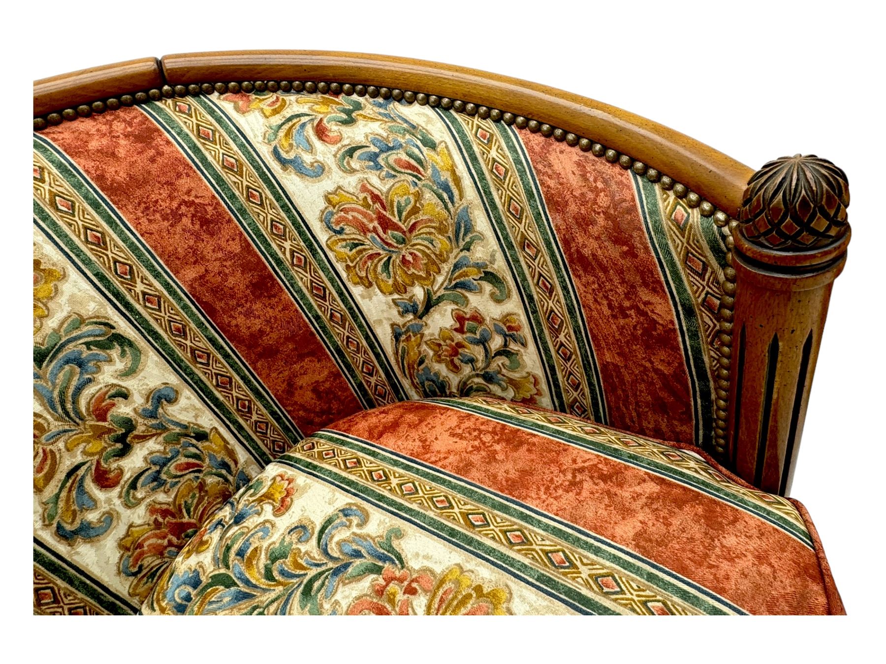 Pair of cherry wood framed tub-shaped armchairs, upholstered in striped floral fabric with brass stud trim, carved walnut frame with fluted supports capped with pinecone finials, on turned feet