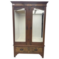 Edwardian figured walnut double wardrobe, carved with foliate decoration, fitted with two bevelled mirror doors, single drawer fitted to base