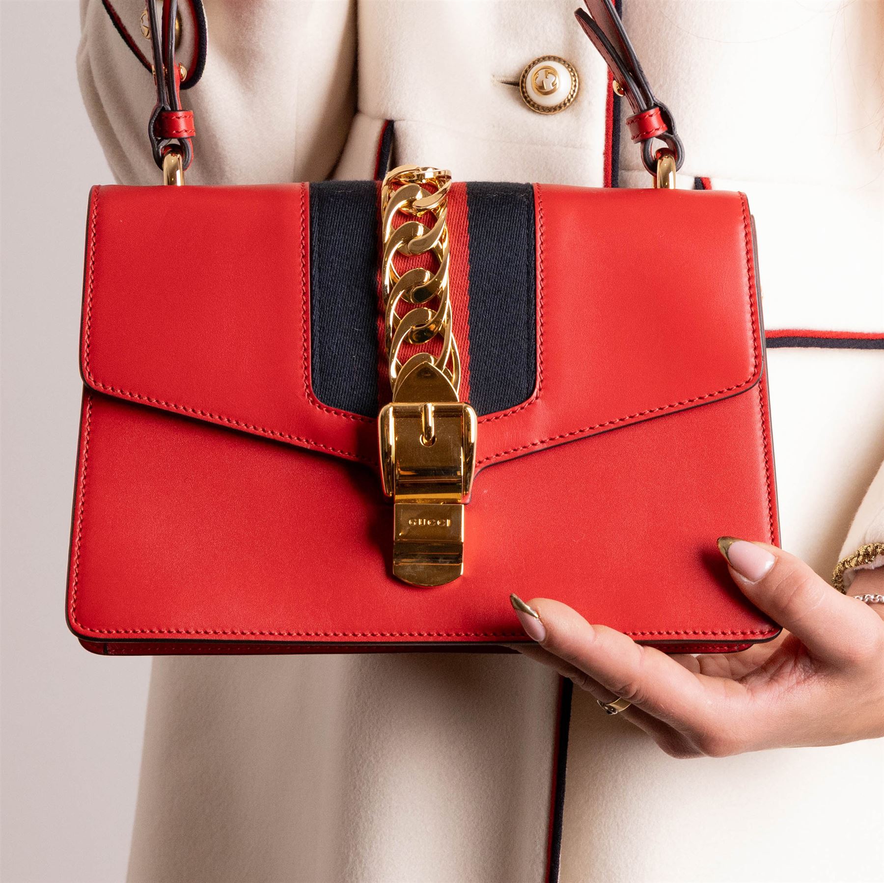 Gucci - ‘Sylvie’ Small Shoulder Bag, introduced circa 2016 under Alessandro Michele, in red calfskin leather with signature web stripe, gold-tone chain and buckle fastening and hardware, flat leather shoulder strap with alternative web-stripe grosgrain strap, unused with original dust bag