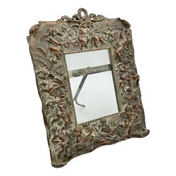 20th century copper frame, decorated in relief with cherubs and putties in foliate surround, H29cm