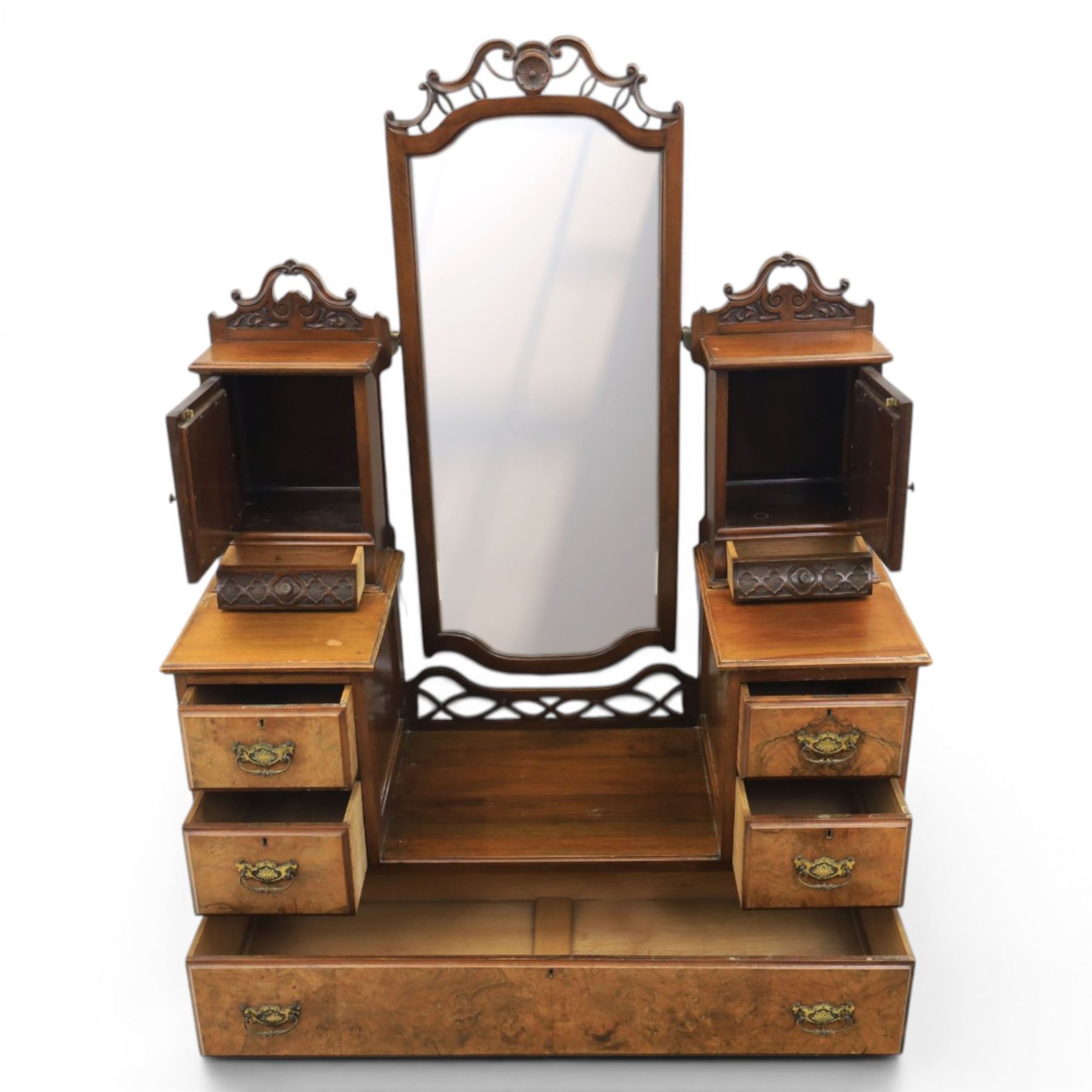 Edwardian figured walnut dressing chest, with central tilting mirror with pierced fret work, flanked by cabinet with figured walnut panelled door above a trinket drawer, with four short over a long long drawer, raised on a plinth base with castors 