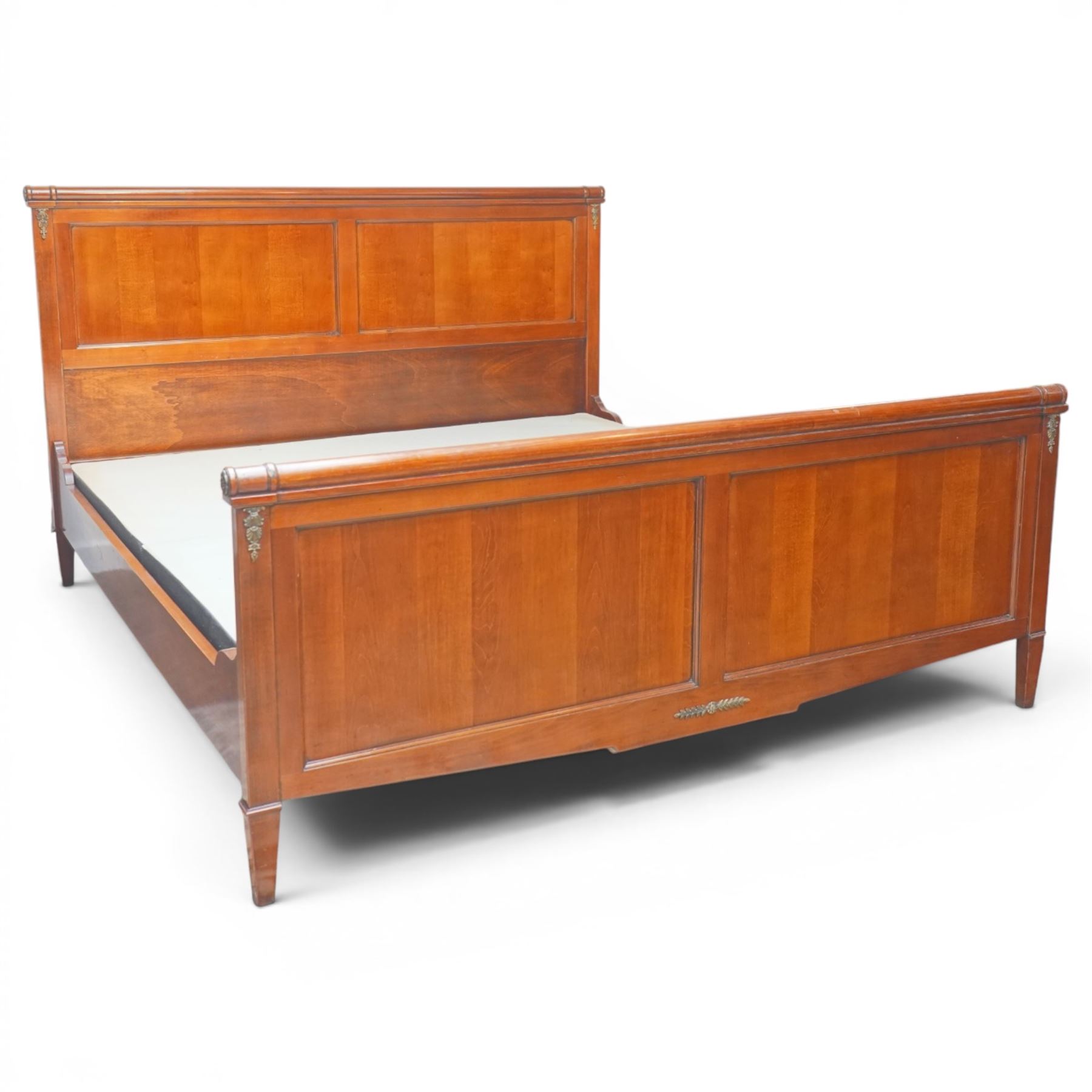 And So To Bed - cherrywood 6' super king 'Nathalie' bed, the panelled headboard and footboard with cylindrical rolled rails, decorative brass mounts to the corners, on square supports with cream and black edged fabric covered base panels 