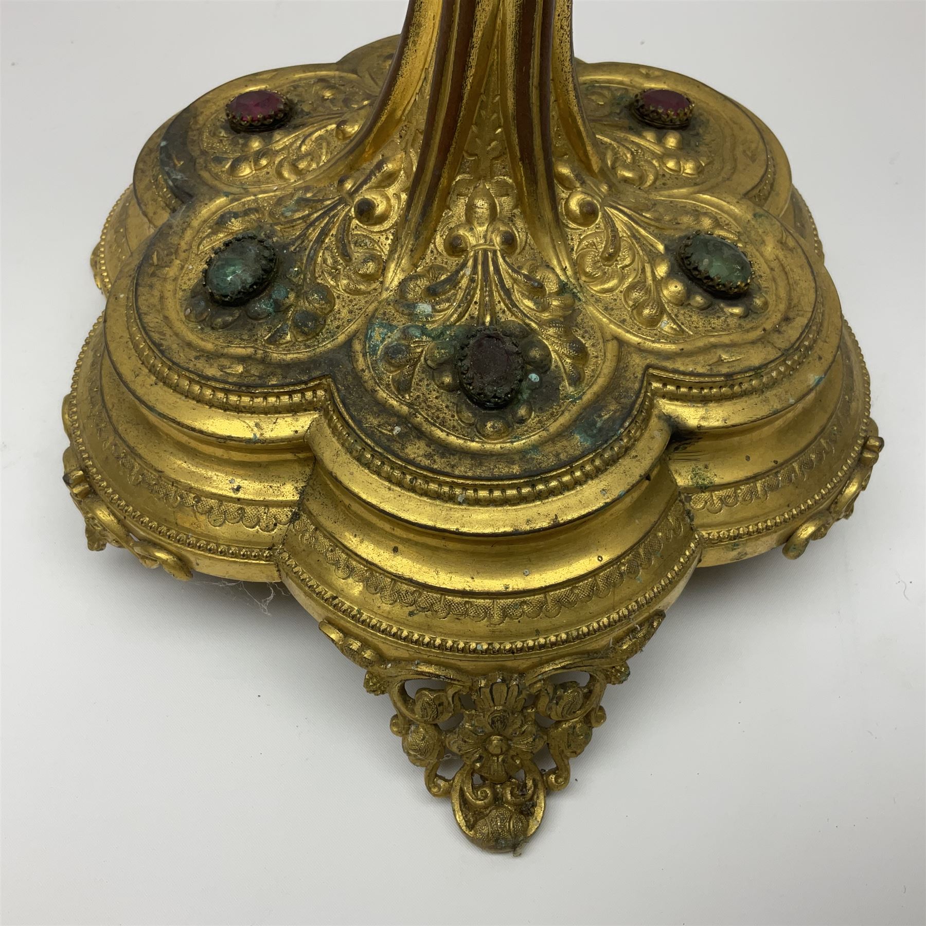 20th century gilt metal monstrance, in the Gothic revival style, with glazed aperture to centre surrounded with clear paste stones, in a pierced floral and scroll border set with coloured paste stones, within a sunburst surround, on a paste set knopped stem and similar foliate foot, H59.3cm
