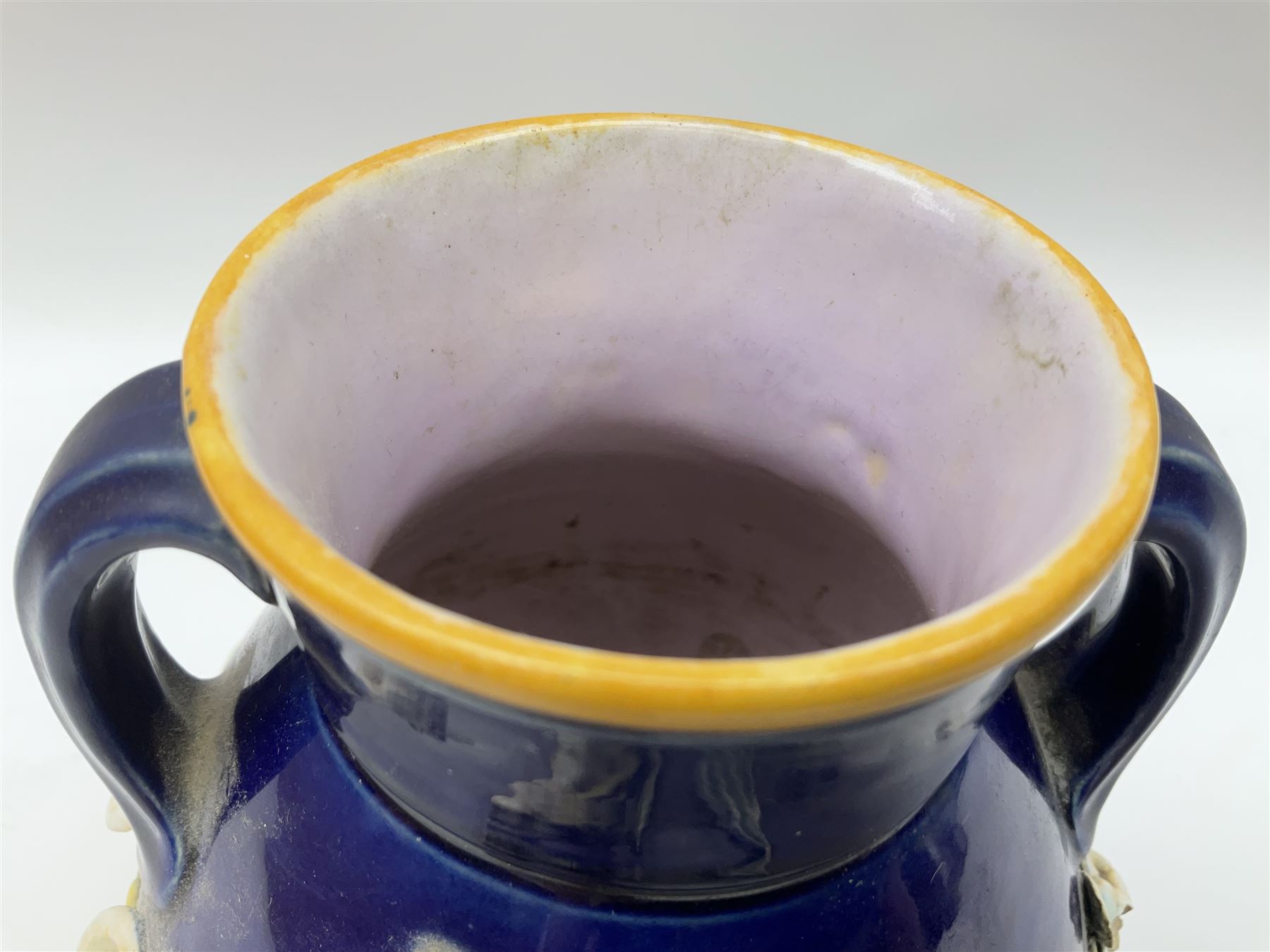 Minton majolica vase, the squat body with twin handles, with part osier moulding and applied Spring flowers against a cobalt blue ground, upon integral square base, impressed beneath Minton 1316, H16.5cm