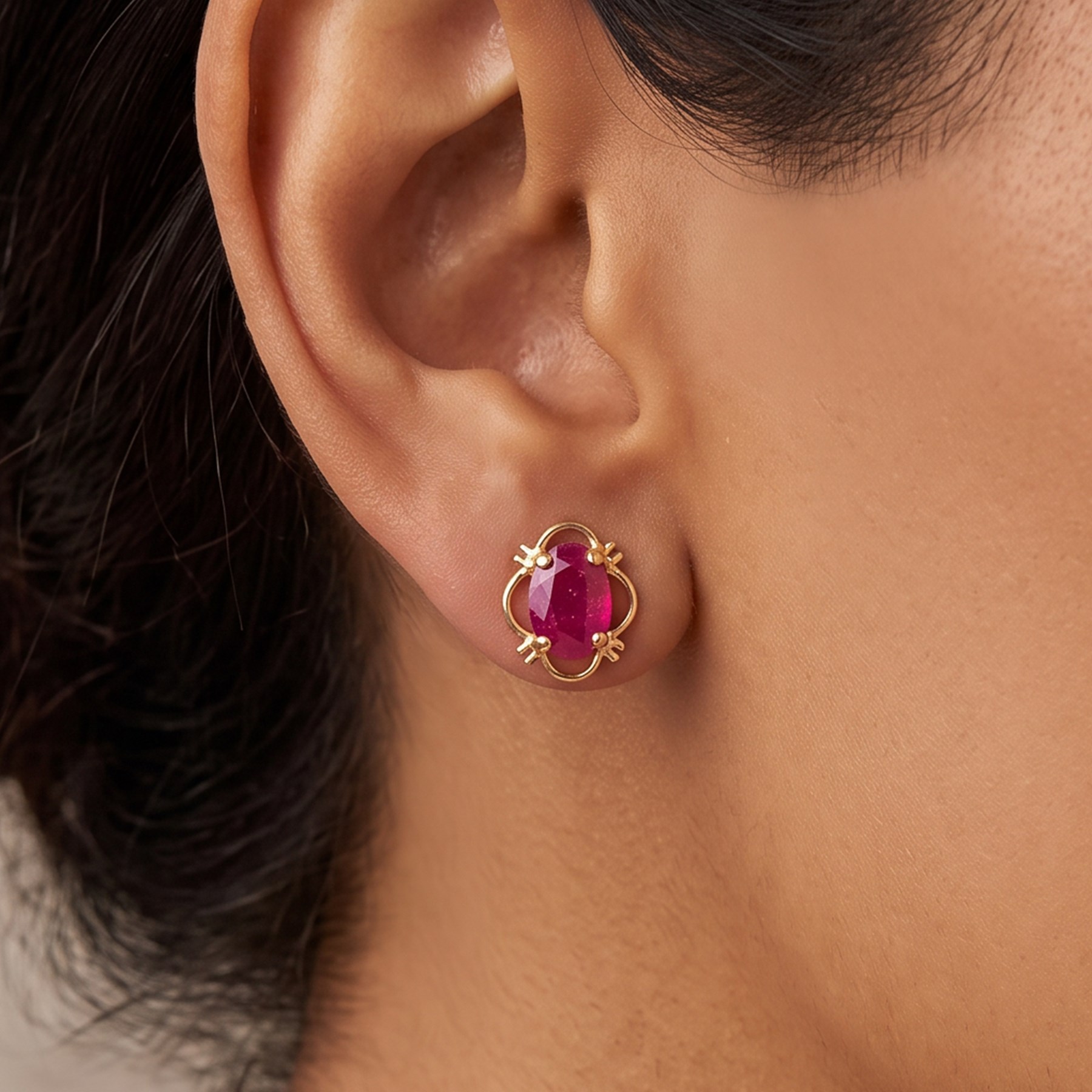 Pair of 9ct gold oval cut ruby stud earrings, stamped