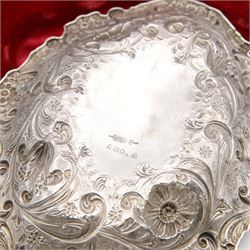 Victorian silver berry dish, of oval form, profusely embossed with floral and foliate decoration, hallmarked Goldsmiths & Silversmiths Co (William Gibson & John Lawrence Langman), London 1894, and a Victorian silver berry spoon, the gilt bowl embossed with berries, hallmarked London 1846, maker's mark worn and indistinct, contained within a tooled leather retailers case for Goldsmiths & Silversmiths London, both also with French weevil import marks, bowl end to end W27cm
