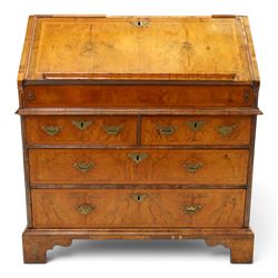 18th century figured walnut bureau, the sloped fall-front enclosing fitted interior with sliding base, pigeon-holes and correspondence drawers with shaped facias, over two short and two long feather-banded drawers with pressed brass handle plates, on bracket feet