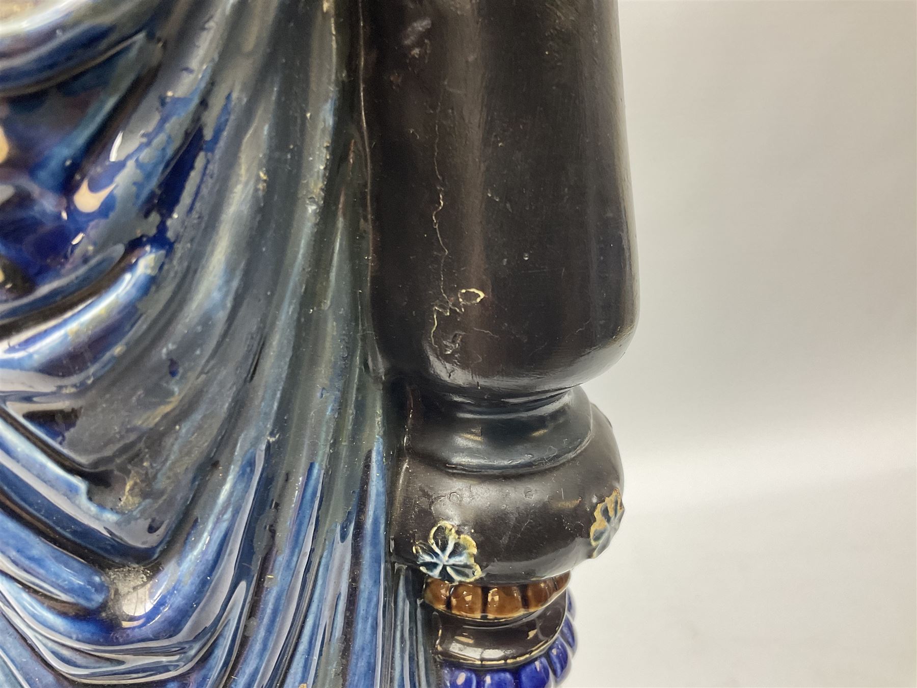 Composite table lamp modelled as a Roman Emperor donning blue robes, upon quatrefoil base modelled with rams heads and winged cherubs, H56cm excl fitting