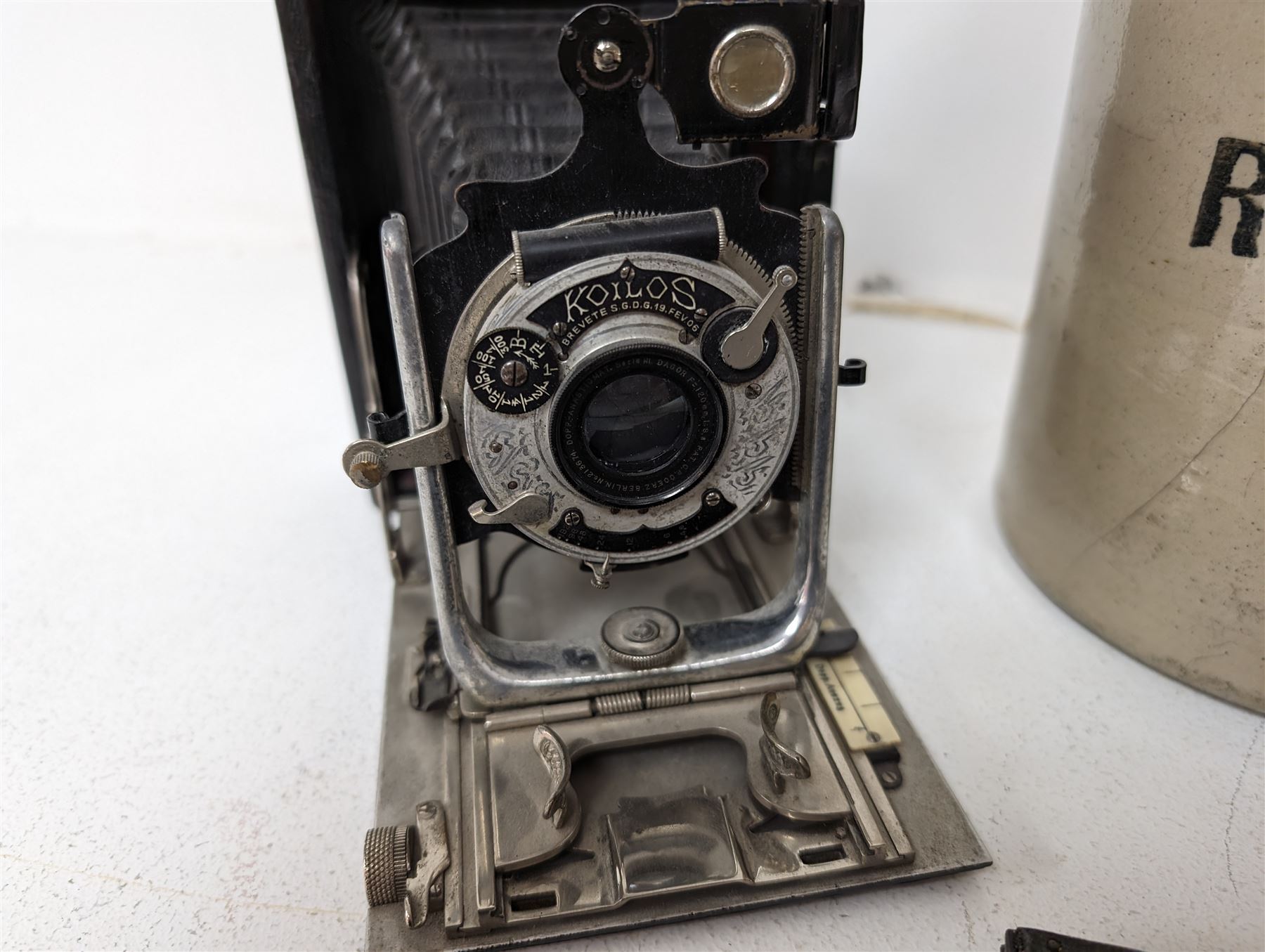 Watt & Ferguson Botanical Brewers stoneware flagon, together with a Sherwoods copper and brass lamp and a Koilos Minimal plate camera, flagon H26.5cm
