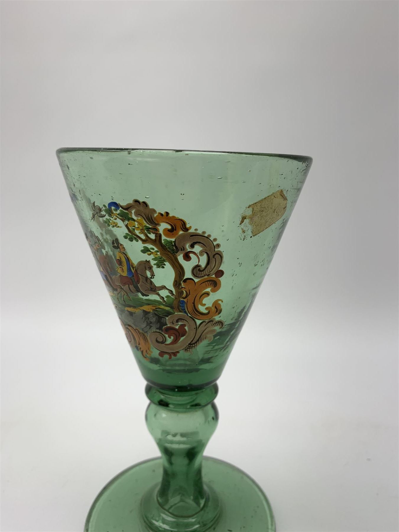 19th century bohemian green glass wine glass, the funnel bowl decorated in enamells with a Historismus hunting scene in the manner of Egermann & Lobmeyr, upon a baluster stem and circular foot, H14.5cm