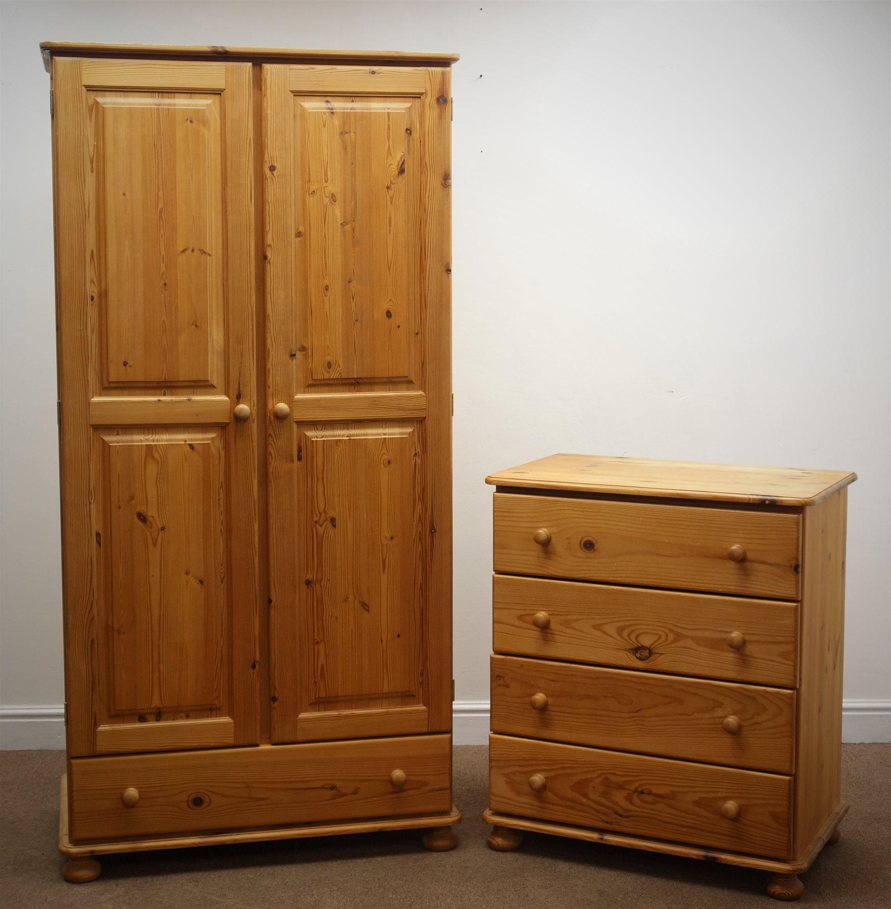 Solid pine wardrobe, two panelled doors above single drawer, on bun