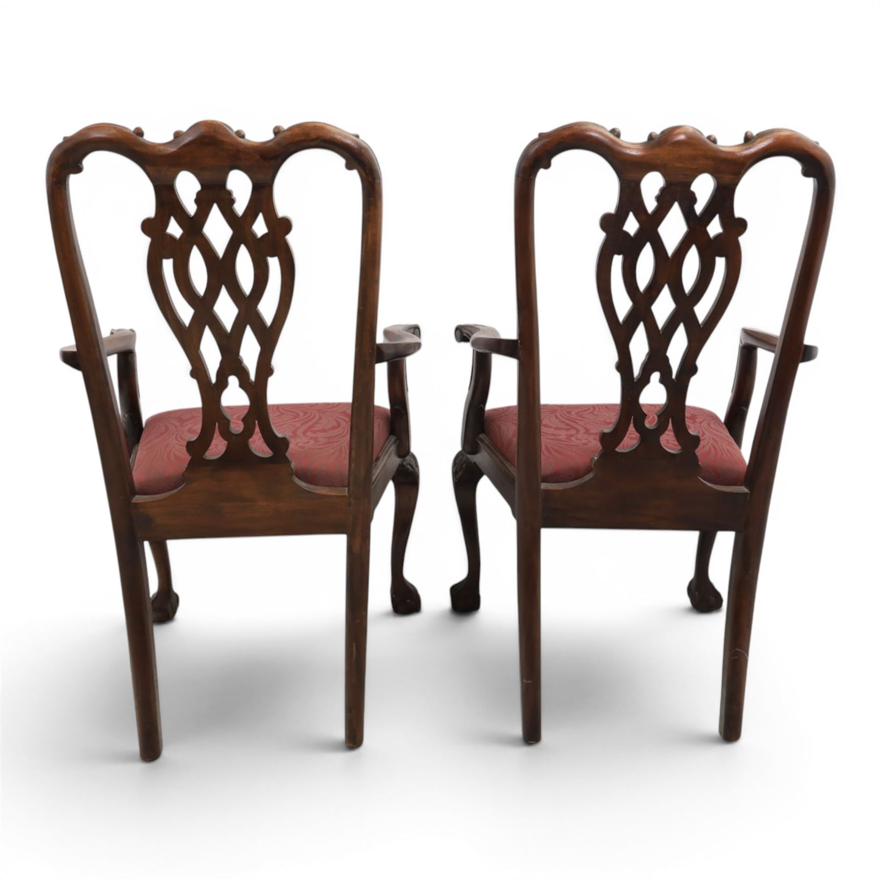 Chippendale design set of ten (8+2) mahogany dining chairs, serpentine cresting rails with carved detail over pierced ribbon-tied splats, red damask upholstered drop-in seats, on cabriole supports with acanthus carved knees and claw and ball feet