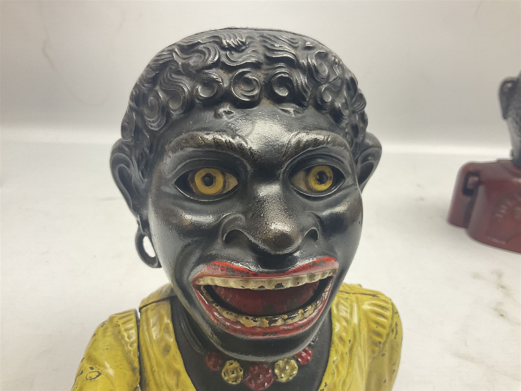 Three early 20th century cast-iron mechanical money banks as a family group comprising mother 'Dinah' patented 1911, father 'Jolly Man' patented 1902 and son 'Little Joe' patented 1910 by John Harper & Co; all with the same hand-to-mouth action; parents H16cm (3)