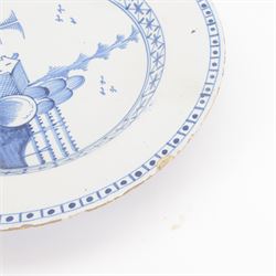 Mid 18th century Lambeth Delft plate, probably from the Abigail Griffith factory, circa 1750, painted in polychrome enamels with a figure seated in a landscape, within a garlanded border of flowers to rim, D34cm, together with a Liverpool Delft plate, circa 1760, painted in blue with a boathouse surrounded by trees by a river, within diaper and cell borders, D37cm