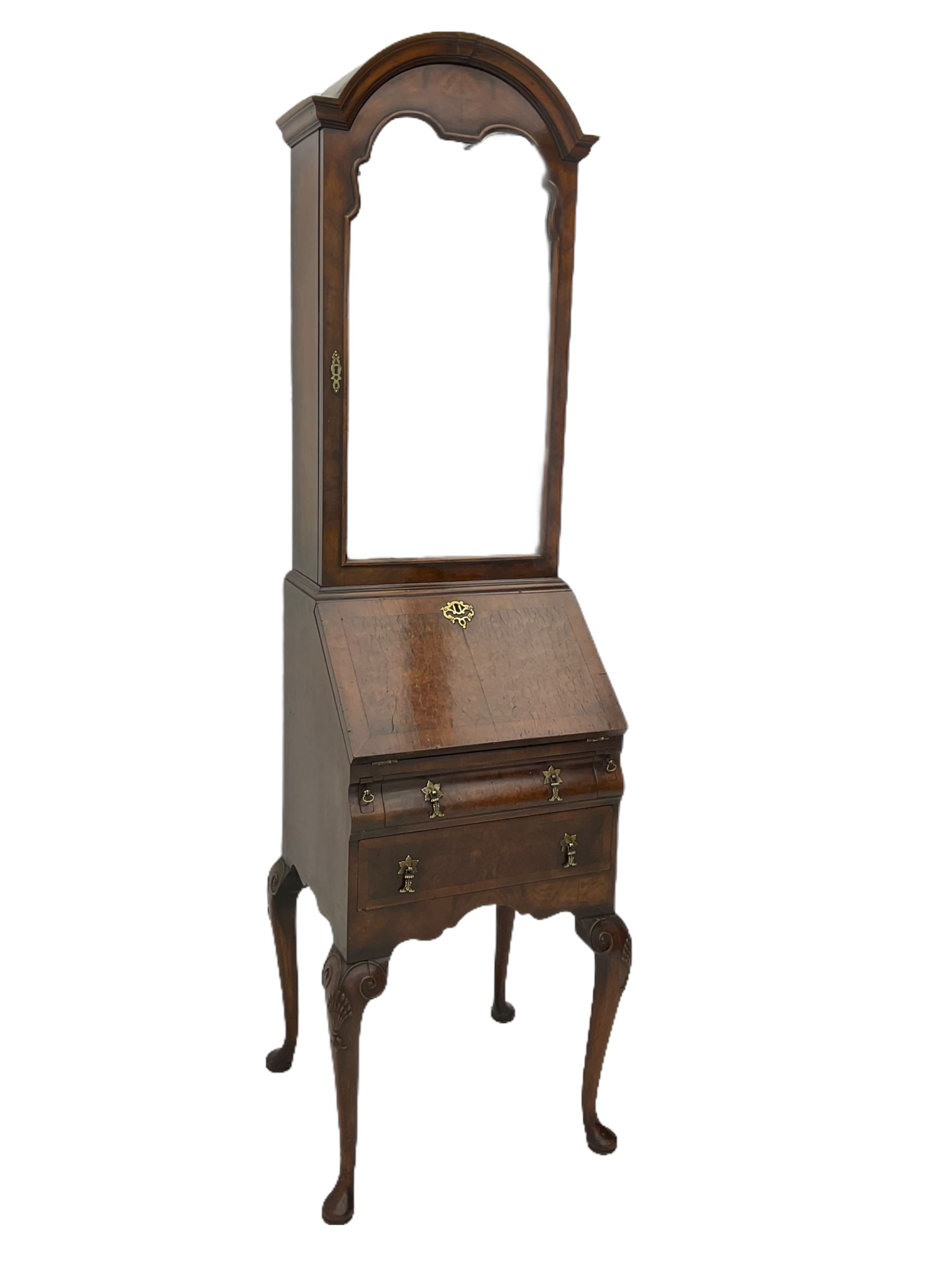 Small early 20th century Queen Anne style bookcase on bureau secretaire, the moulded arched pediment over mirrored door in shaped frame, the bureau fitted with fall front enclosing curved fitted interior, cushion moulded drawer over single drawer, on scroll and shell carved cabriole supports