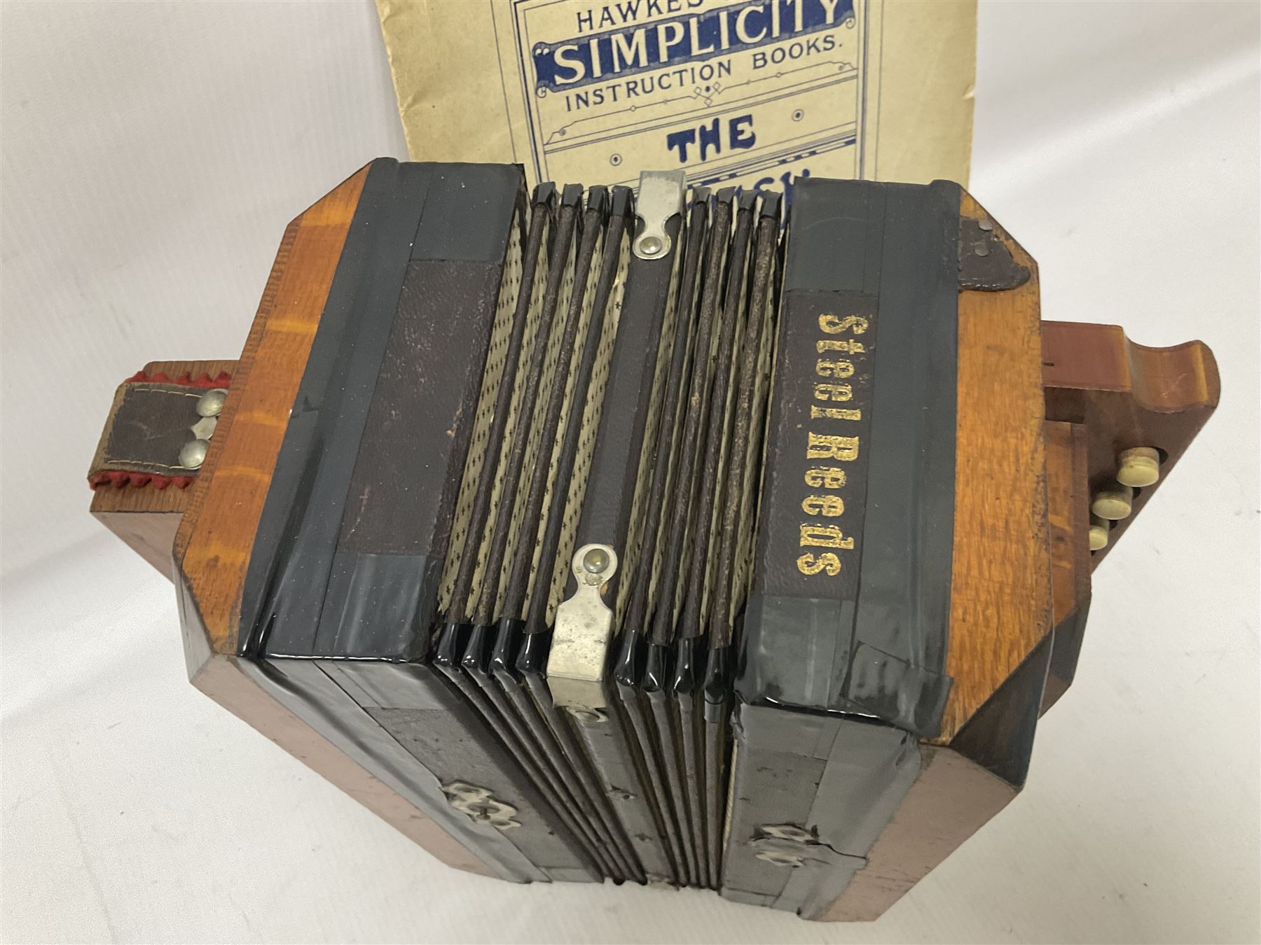 Three European concertinas, comprising Viceroy German concertina with 21 keys, hexagon wooden frame and 8 fold bellows
Oak framed concertina with 12 keys and 8 fold bellows
Commander concertina with 12 keys and 12 fold bellows
With tutor