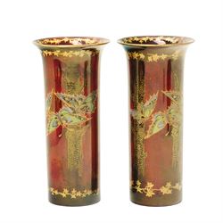 Four pieces of Fielding's Devon Lustrine, comprising a small pair of sleeve vases, H15cm; a bowl and vase, each decorated with butterflies and leaves in gilt on a red ground, printed marks beneath (4)