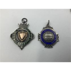Seven early 20th century and later silver and enamel cartouche fobs, all relating to football, to include a circular example, with central rose gold cartouche surrounded by a green enamel border, hallmarked Birmingham 1927, and six others all hallmarked with various dates and makers
