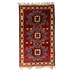 Caucasian Kazak hand-knotted rug, madder red ground with three large stepped geometric med...