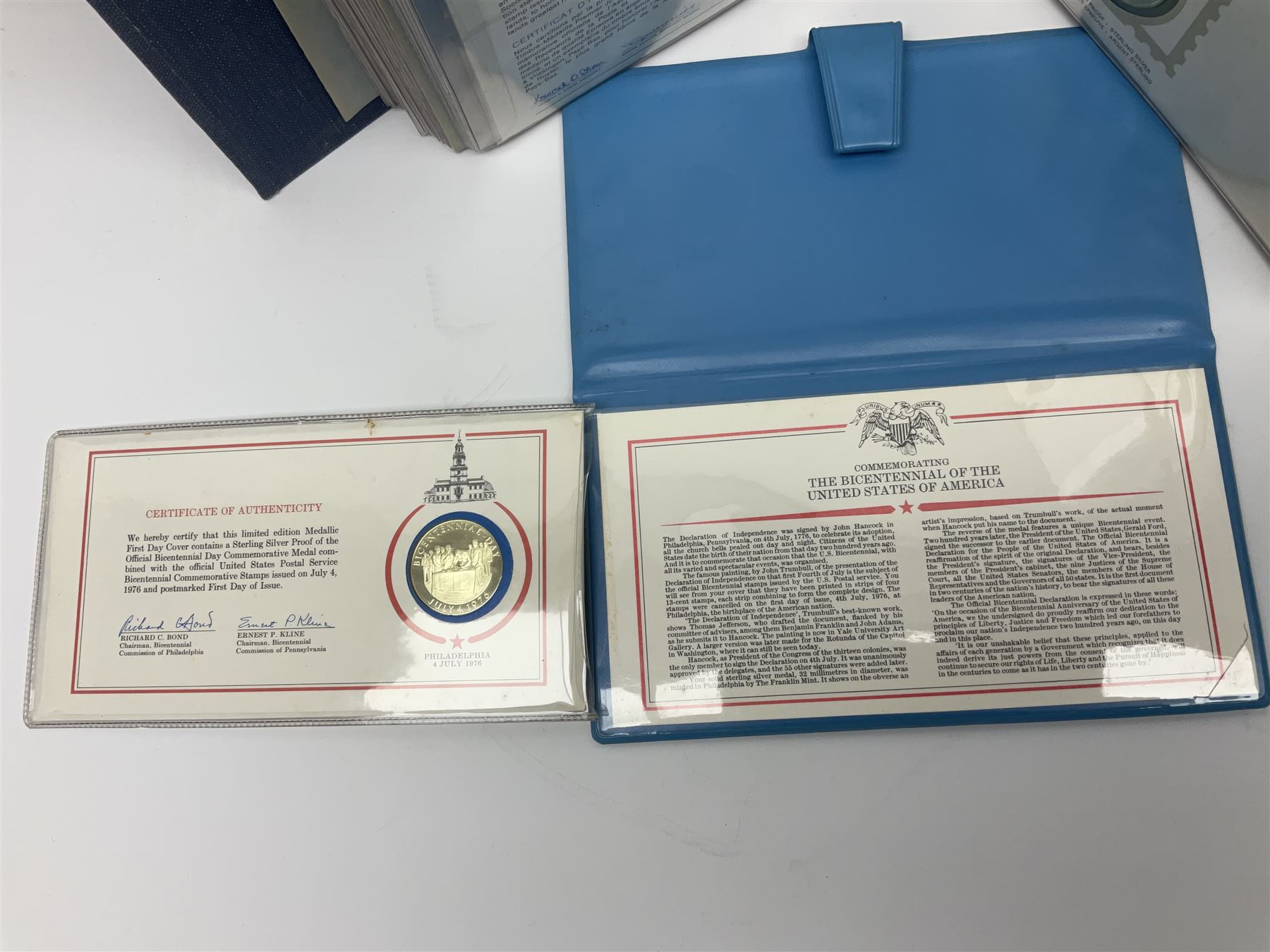 Thirty-one 'International Society of Postmasters Official Commemorative Issues' sterling silver proof medallic covers dating from 1975 to1977, housed in the official folder and a 'Commemorating The Bicentennial Of The United States Of America' sterling silver proof medallic first day cover in blue wallet