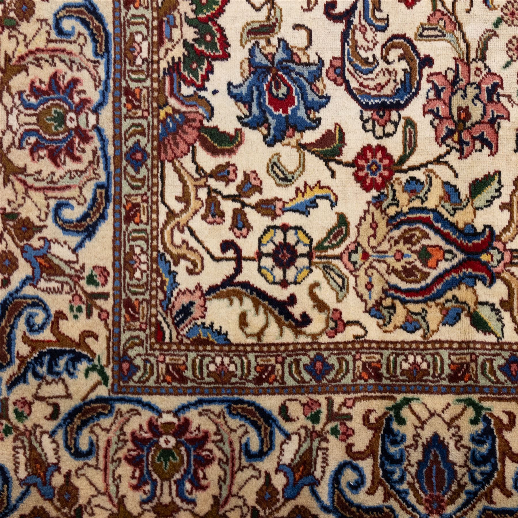 North West Persian Tabriz, hand-knotted carpet, ivory ground with dense scrolling vine-work, palmettes, flowering sprays, and stylized leaves framed by a principal border of scrolling floral motifs and palmettes and flanked by narrow guard borders, with cotton fringe ends