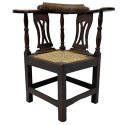18th century country elm and oak corner chair, the shaped cresting rail terminating to swept arm resets, supported by turned columns and pierced shaped splats, over a drop-in rush seat, raised on square supports united by box stretcher