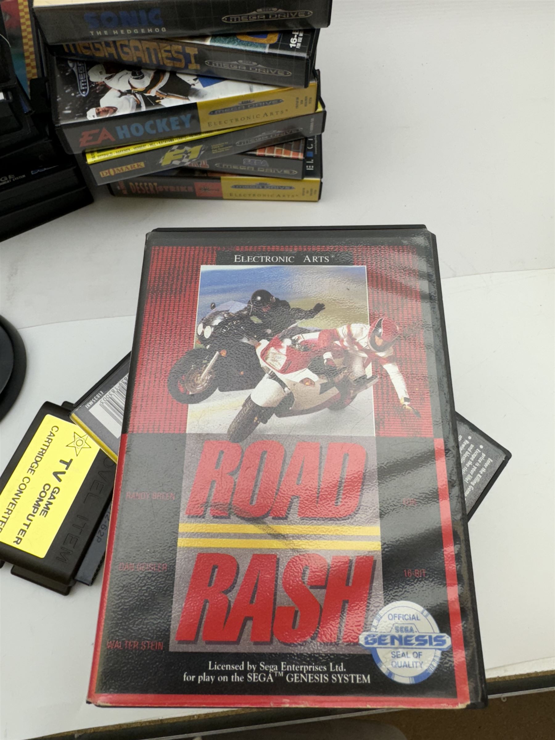 Eighteen Sega Mega Drive games, including Sonic The Hedgehog, Sonic The Hedgehog 2, Alienstorm, Desert Strike, Fatal Rewind, Road Rash etc, all boxed, together with a Sega Mega Drive controller, cartridge converter and an arcade power stick controller