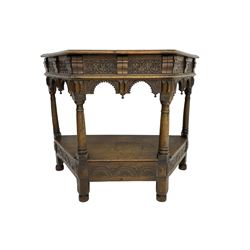 Jacobean design carved oak side or credence table, demi-heptagon top with moulded edge, frieze carved with foliate C-scroll design above ornate arcade carved apron, under-tier united by ring turned pilisters, lower frieze carved with repeating lunettes