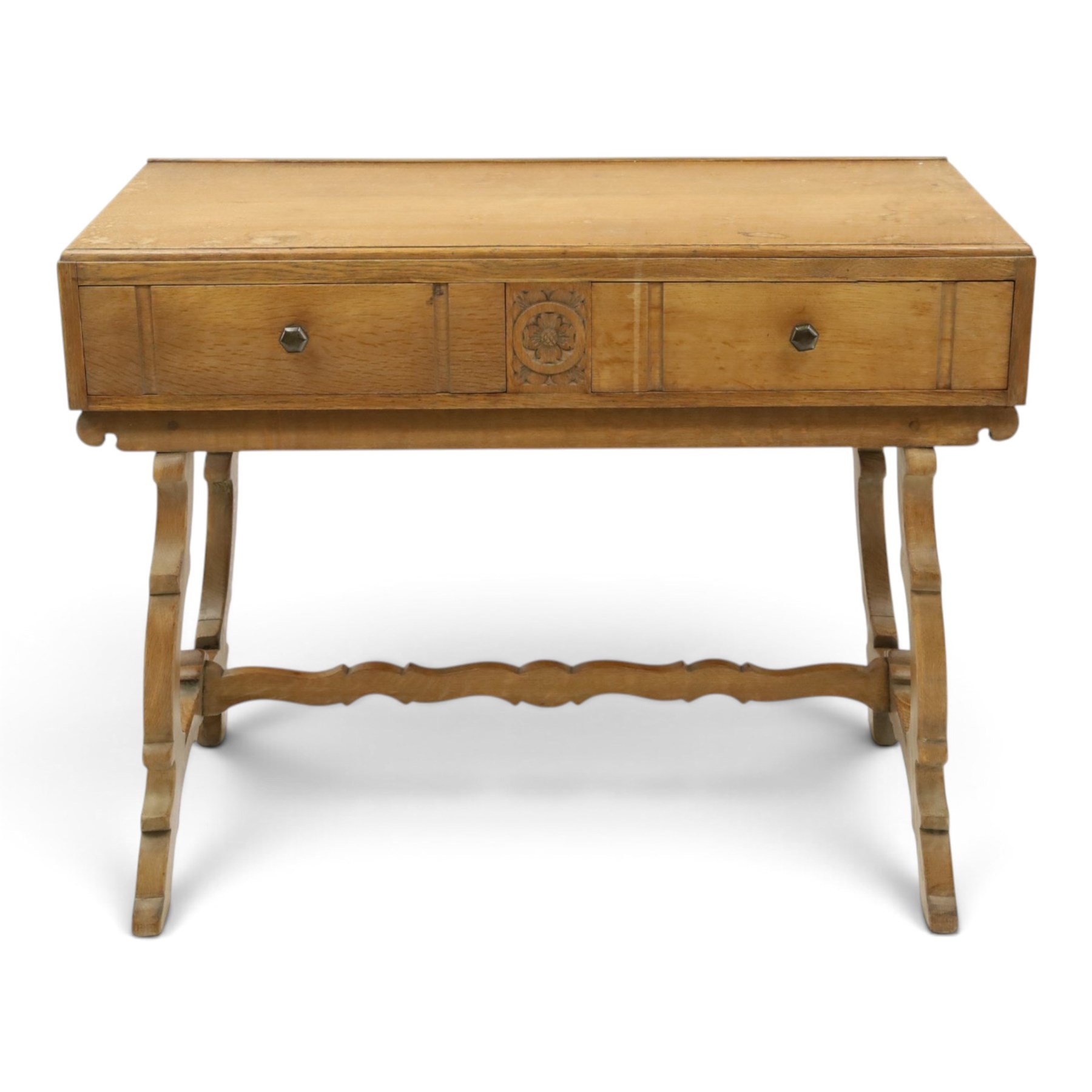 Leemings of Halifax (est. 1872) - Arts & Crafts oak side table, rectangular caddy top with raised moulded back, the frieze carved with central Yorkshire rose motif flanked by two drawers, raised on twin stylised lyre end supports formed of C-scrolls, united by shaped stretcher