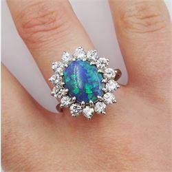 White gold oval black opal and round brilliant cut diamond cluster ring, opal approx 11.4mm x 8.5mm x depth 5mm, total diamond weight approx 1.05 carat, stamped 18ct