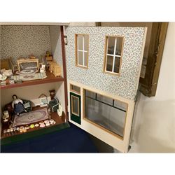 Good quality late 20th century dolls house by M. James dated 1996 in the form of 'Graysons' Shop with two storeys above; textured brick walls under a faux slated pitched roof with dormer window, hinged along the ridge giving access to a single attic room; the hinged front elevation with large glazed shop window and opening customer door; single room shop with first floor room over currently furnished with various scale domestic items including settee and armchair, longcase clock, chests of drawers, tables, chairs etc; together with bakery stock of cakes, pies, bread loaves and biscuit tins W39cm H79.5cm D33cm