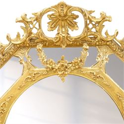 Late 19th century French giltwood and gesso wall hanging cushion mirror, the pierced foliate rocaille pediment extending acanthi C-scrolls and trailing bellflowers, over a floral garland and cartouche moulded rails, the central oval bevelled plate surrounded by further bevelled cushion mirrors, with out-scrolling pierced motifs flanking the floral egg-and-dart moulded outer edge, over a pierced foliate cartouche terminal