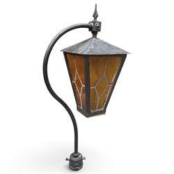 REVO Electric Co. Ltd., Tipton - early 20th century cast iron street lamp standard, the later hexagonal lantern with amber leaded glazing and pointed finial, supported on a swan-neck bracket above a ring-turned capital, tapering column and ladder rest, terminating in a moulded scrolling foliate-decorated base with lappet collar, stamped REVO

Provenance: formerly installed as street lighting in Prestwich, Greater Manchester