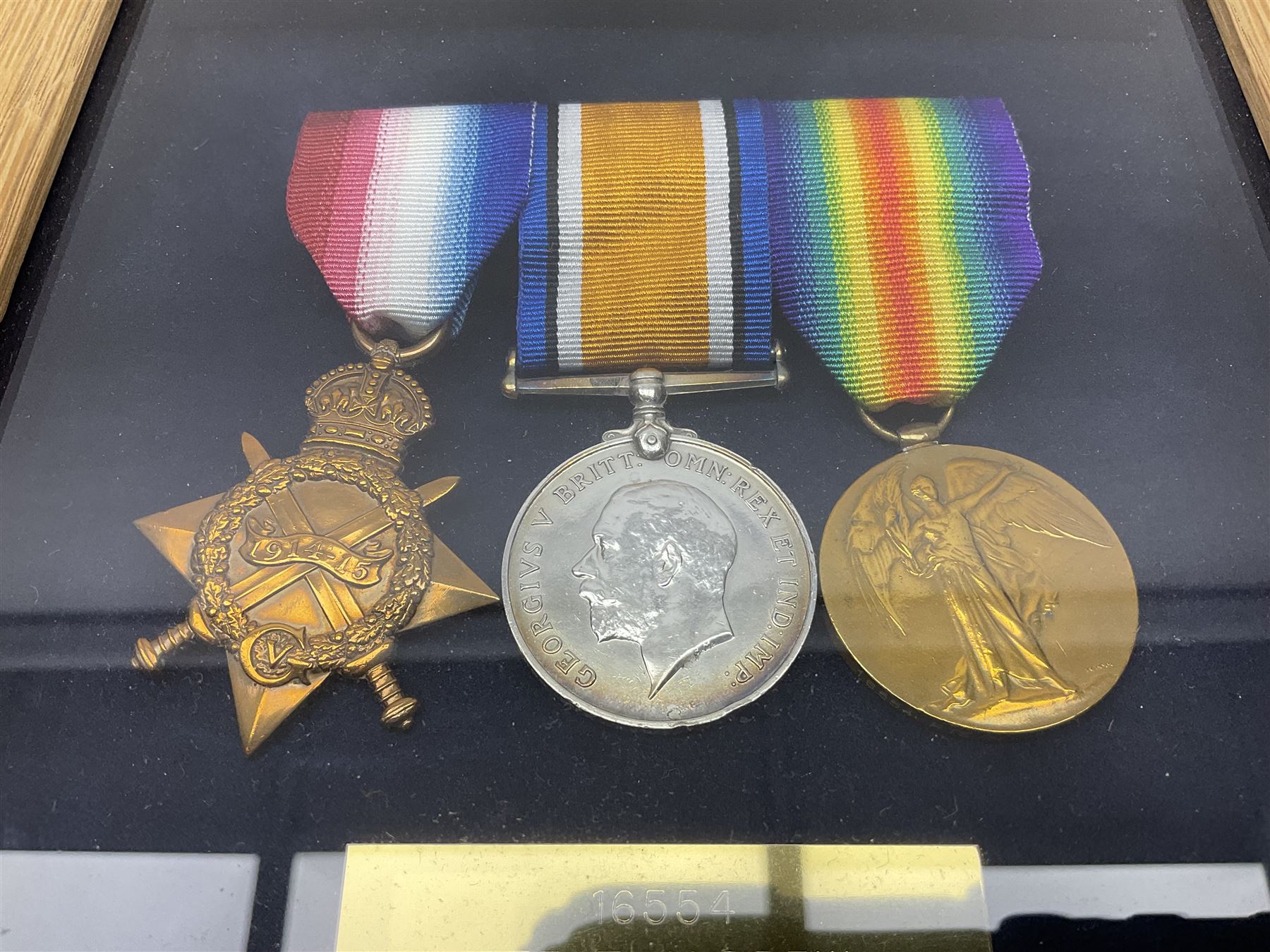 WWI group of three medals with bronze memorial plaque comprising 1914-15 Star, British War Medal and Victory Medal awarded to 16554 Pte. T. Andrew Linc. R. who died on 26th July 1916 whilst travelling to Vimy Ridge, polished and mounted for display in a frame; together with small archive of research material and two WWII V.E. Day Presentation Certificates from the people of Holbeach in Lincolnshire