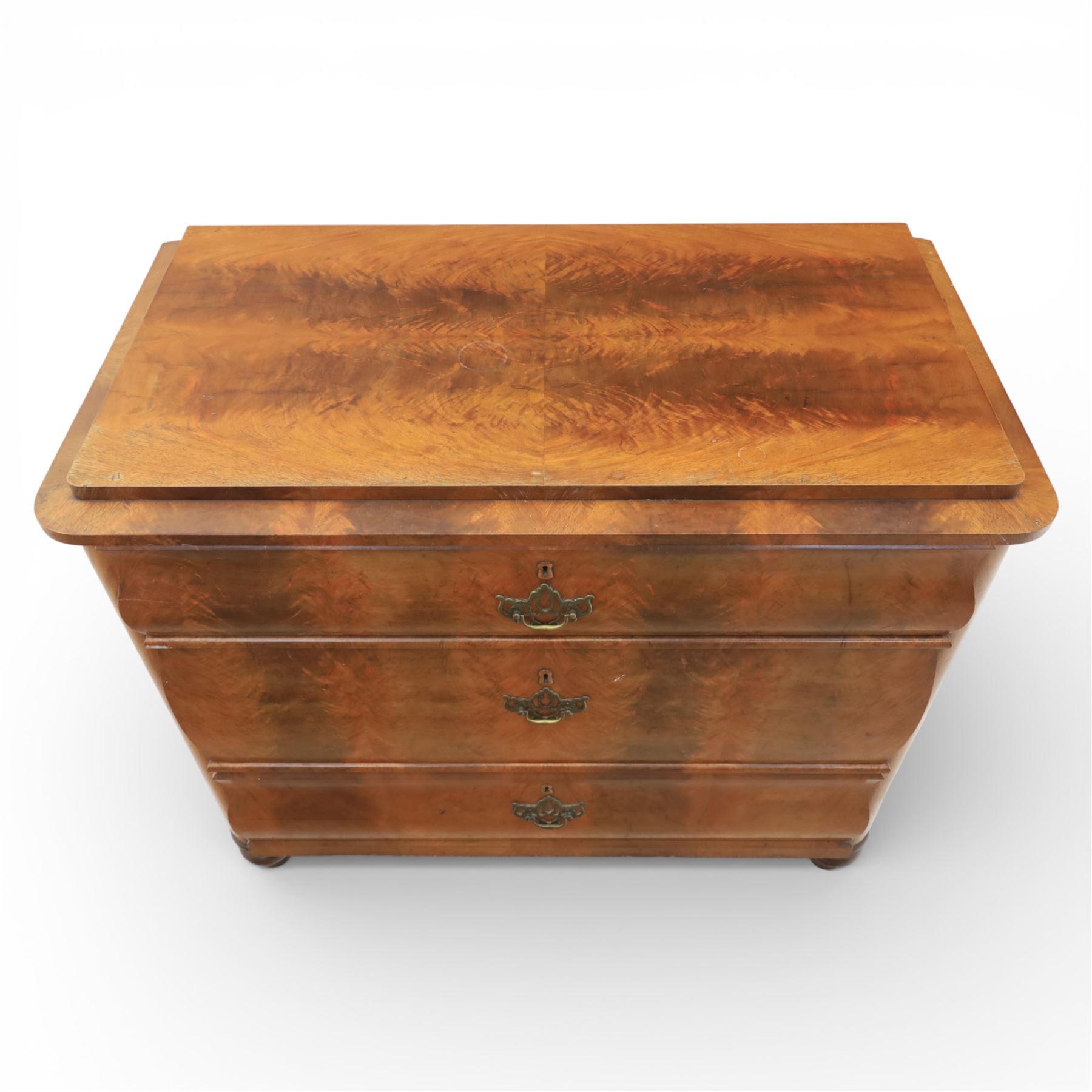 Late Victorian walnut and burr walnut chest of drawers, moulded top with rounded corners, finely figured burr walnut drawer fronts arranged as three long drawers, brass batwing handle plates, the lower section raised on turned bun feet